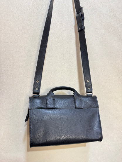 Black leather briefcase with shoulder strap on a light beige background